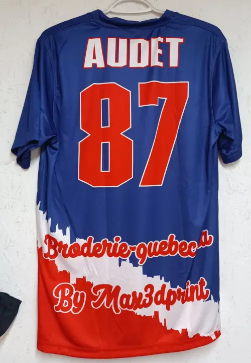 Maillot de sport bleu, rouge et blanc avec "Audet" et "87", brodé par Broderie-quebec.ca.