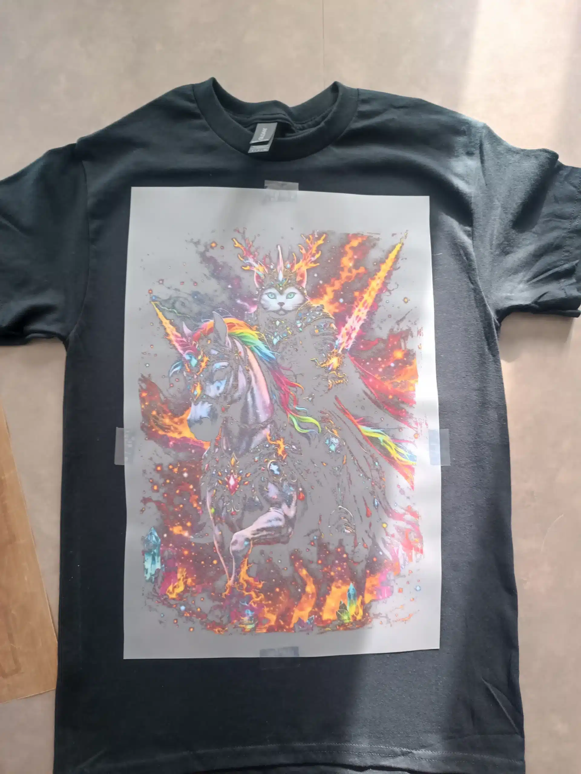 Transfert DTF positionné sur un T-shirt noir avant le pressage.